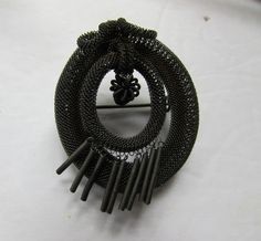 "Unusual antique Victorian era brooch. This is challenging our descriptive talents. The oval shaped brooch is of woven fine gauge metal in a form similar to Victorian hair woven jewelry. This has almost an industrial look to it. The outer rim is tightly woven and serves as the anchoring cartouche. At the top, a dangling ball and crest leads to a smaller woven oval cartouche. This holds 9 twisted, spring-like 1/2\" tails. This is possibly a piece of mourning jewelry. The back has the c-clasp--cau Antique Oval Brooches For Evening, Oval Brooches For Evening, Oval Evening Brooches, 1940 Style, Antique Jewelry Victorian, Victorian Hair, Woven Jewelry, Woven Metal, Jewelry Victorian