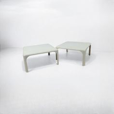 two white tables sitting side by side on a white surface with one end turned upside down