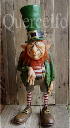 a statue of a man with a green top hat and striped socks is standing on a wooden floor