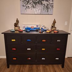 a black dresser with toy cars on it