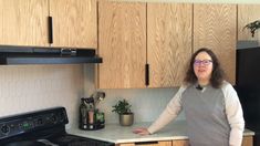 a woman standing in a kitchen next to an oven