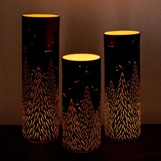 three black vases sitting on top of a wooden table