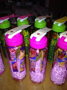 four plastic bottles with candy in them sitting on a table