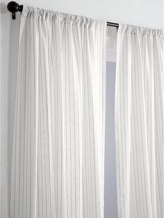 a white curtain hanging on the side of a wall next to a black door handle