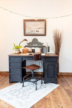 a desk with a chair, lamp and pictures on the wall