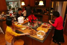 a group of people in a kitchen preparing food on a counter top with plates and pans