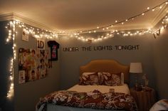 a bed room with a neatly made bed and string lights