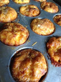 several muffins in a metal pan on top of a stove burner with other muffins