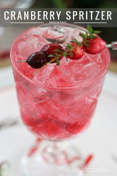 the cranberry spritzer cocktail is garnished with cherries