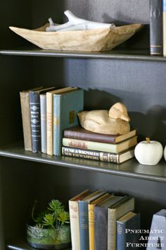 some books are sitting on the shelves in front of each other and there is a paper boat