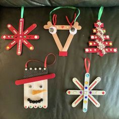 christmas ornaments made out of popsicle sticks on a leather surface with string and bead