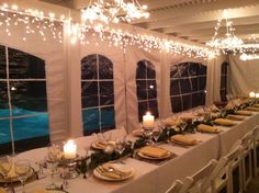 a long table is set with plates and candles