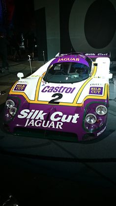 a purple and yellow race car is on display