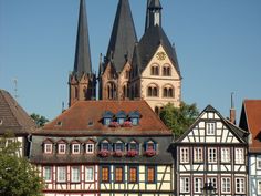 an old building with many windows and spires in front of some other buildings on the street