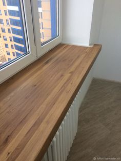 an empty room with a window and wooden counter top