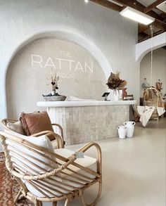 the interior of a store with white walls and furniture in front of an arched window