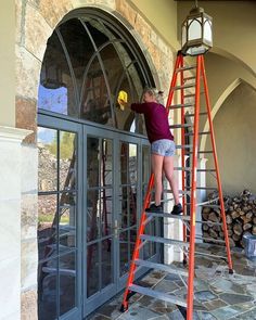 a person on a ladder cleaning windows