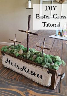 a wooden box filled with moss and three crosses