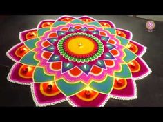 a colorful flower design with candles on the floor