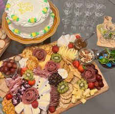 an assortment of cheeses, crackers and fruit on a platter