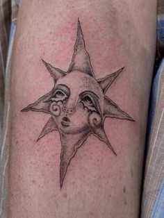 a tattoo on the leg of a man with a sun face and two small eyes