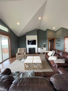 a living room with couches, chairs and a fireplace in the middle of it