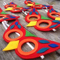 several pieces of felt with colorful designs on them sitting on a wooden table next to scissors