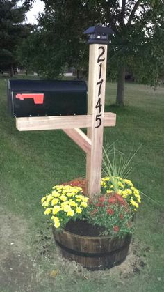 a mailbox and flower pot in the grass