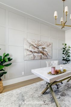 a living room with a white table and some plants