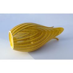 a yellow vase sitting on top of a white table