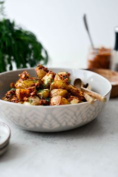 a bowl filled with food sitting on top of a table next to a knife and fork