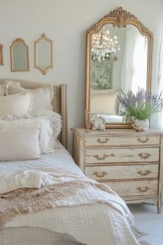 a bedroom with a bed, dresser and mirror on the wall next to each other