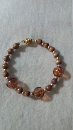 Hand blown hollow glass beaded bracelet.  Brown wooden beads with light gold pearl spacers & magnetic clasp.  Light cocoa transparent glass bubbles. Please don't hesitate to contact me should you have any questions or concerns. Thank you for visiting my shop and I look forward to you stopping by again soon. Cheap Brown Jewelry With Tiny Beads, Gold Beaded Bracelet, Glass Beaded Bracelet, Baby Bling, Baby Bracelet, Gold Bead Bracelets, Cocoa Brown, Crochet Bracelet, Glass Beaded Bracelets