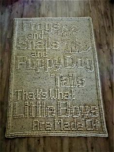 a white rug with words on it sitting on a wooden floor in front of a wall