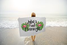 a woman standing on the beach holding a towel that says miles full of flammy