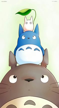 the totoro and cat are sitting on top of each other's head