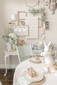 a dining room table set for christmas with decorations on the wall and bunny figurines