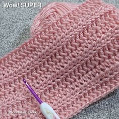 a crocheted pink hat with a purple toothbrush on it and the words wow super written in white