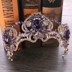 a purple tiara sitting on top of a wooden table next to some book cases