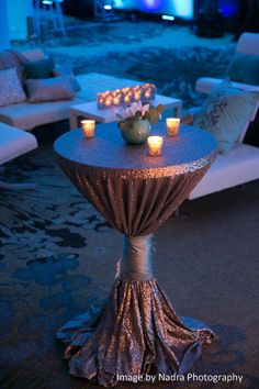 a table that has candles on it in the middle of a room with couches