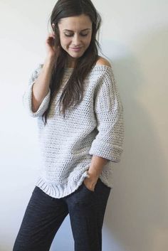 a woman is standing in front of a white wall with her hand on her head