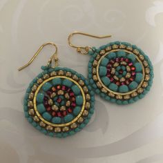 the earrings are decorated with beads and gold