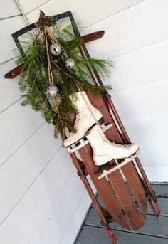 a pair of ice skates sitting on top of a sled with christmas decorations