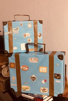 two suitcases are stacked on top of each other with stickers all over them