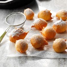 powdered sugar covered pastries on parchment paper with a magnifying glass next to them