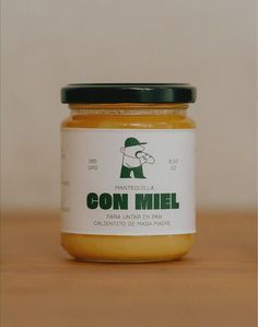 a jar of con miel sitting on top of a wooden table