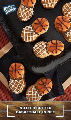 cookies decorated like basketballs are sitting on a black tray with the words nutter butter basketball in net