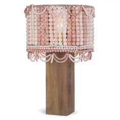 a table lamp with beads on it and a wooden stand in front of the light