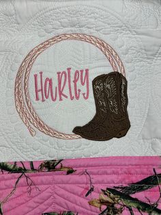 a pink and white quilt with a cowboy boot on it's side that says harley