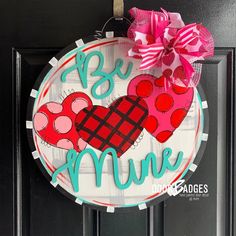 a door hanger that says, be mine with two hearts and a bow on it